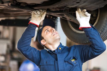 Mechanic inspecting beneath a vehicle